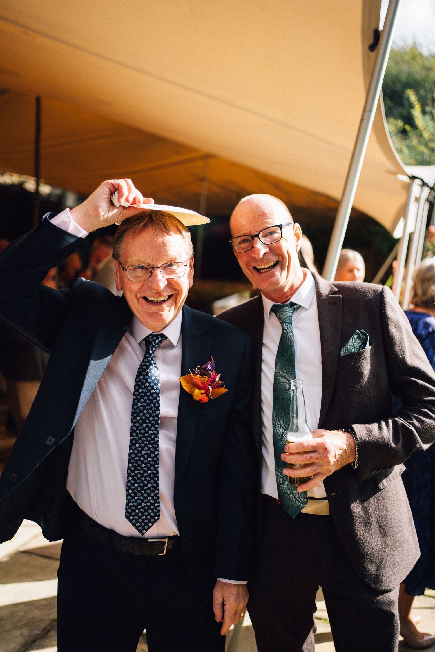 A sequence of candid photos showing joyful laughter and camaraderie between two men at a formal event.
