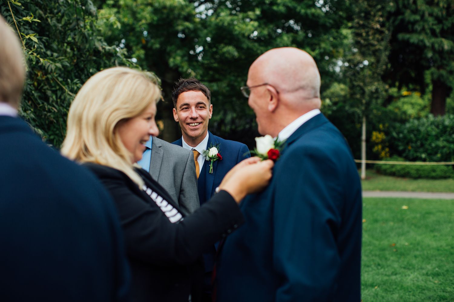 A couple shares a joyful moment together in a lush outdoor garden setting.