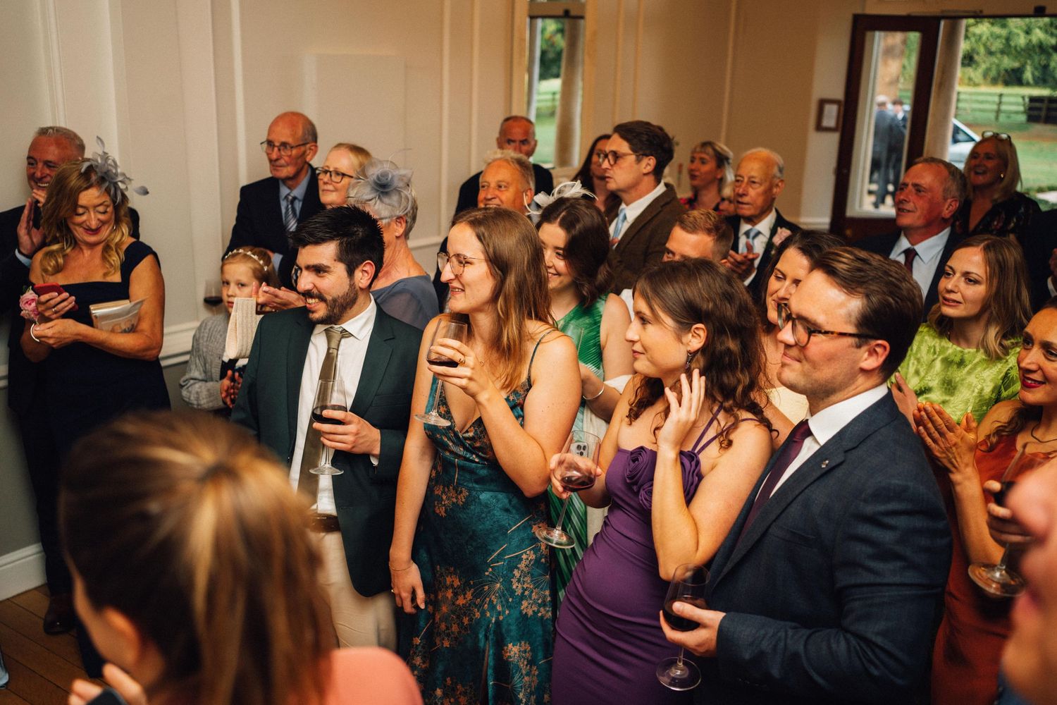 Wedding guests dancing and celebrating together on a dance floor at an indoor reception.