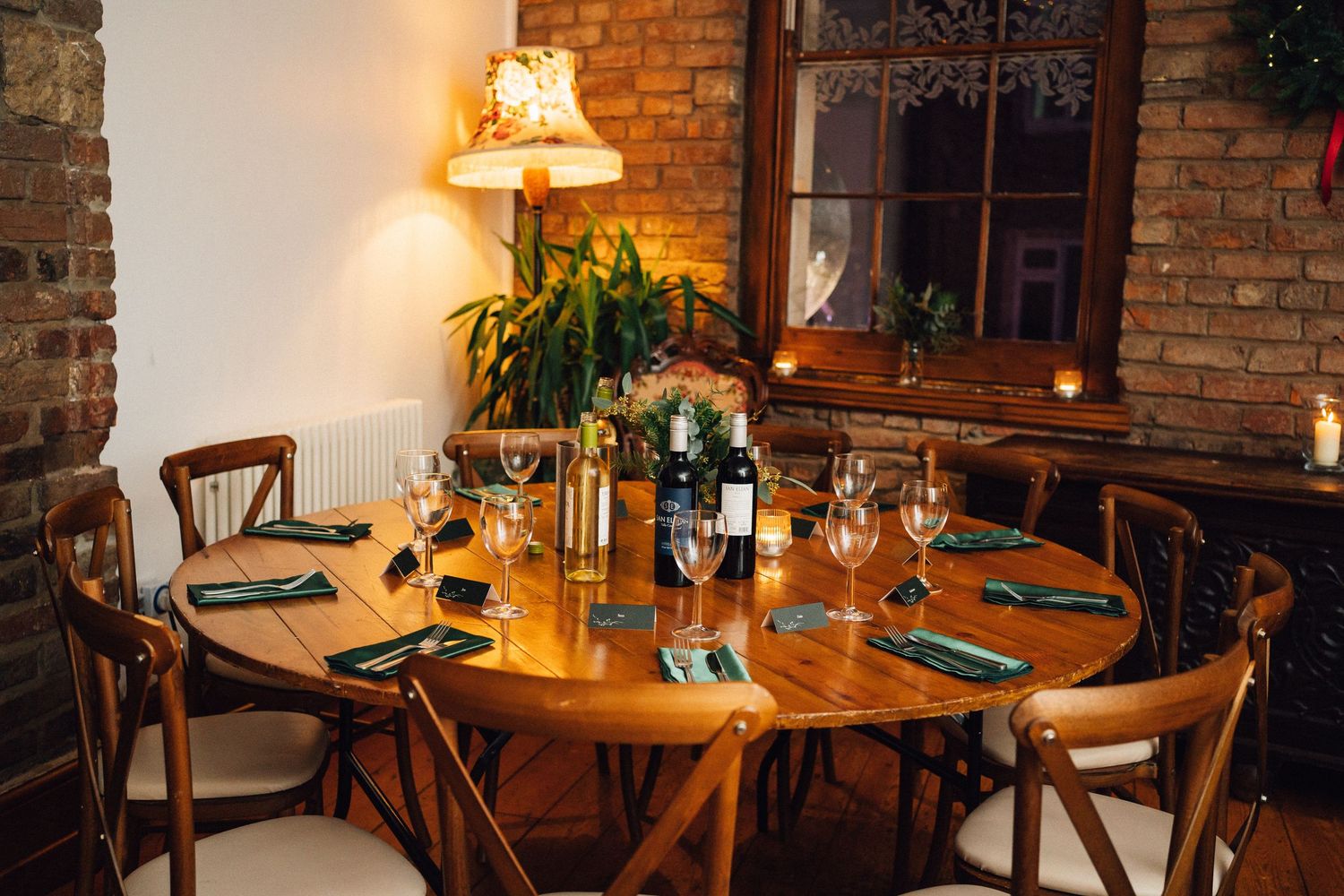 Rustic dining room with exposed brick walls, wooden tables, and warm lighting creating an intimate atmosphere.
