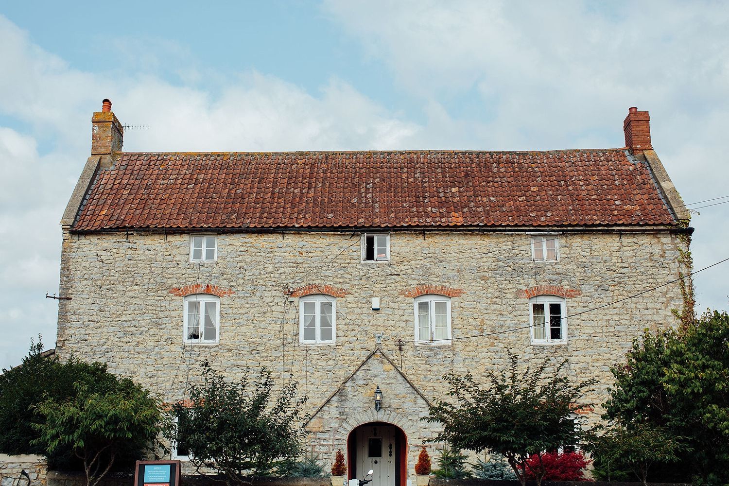 Panoramic view of traditional stone cottages with tiled roofs in a rural setting.