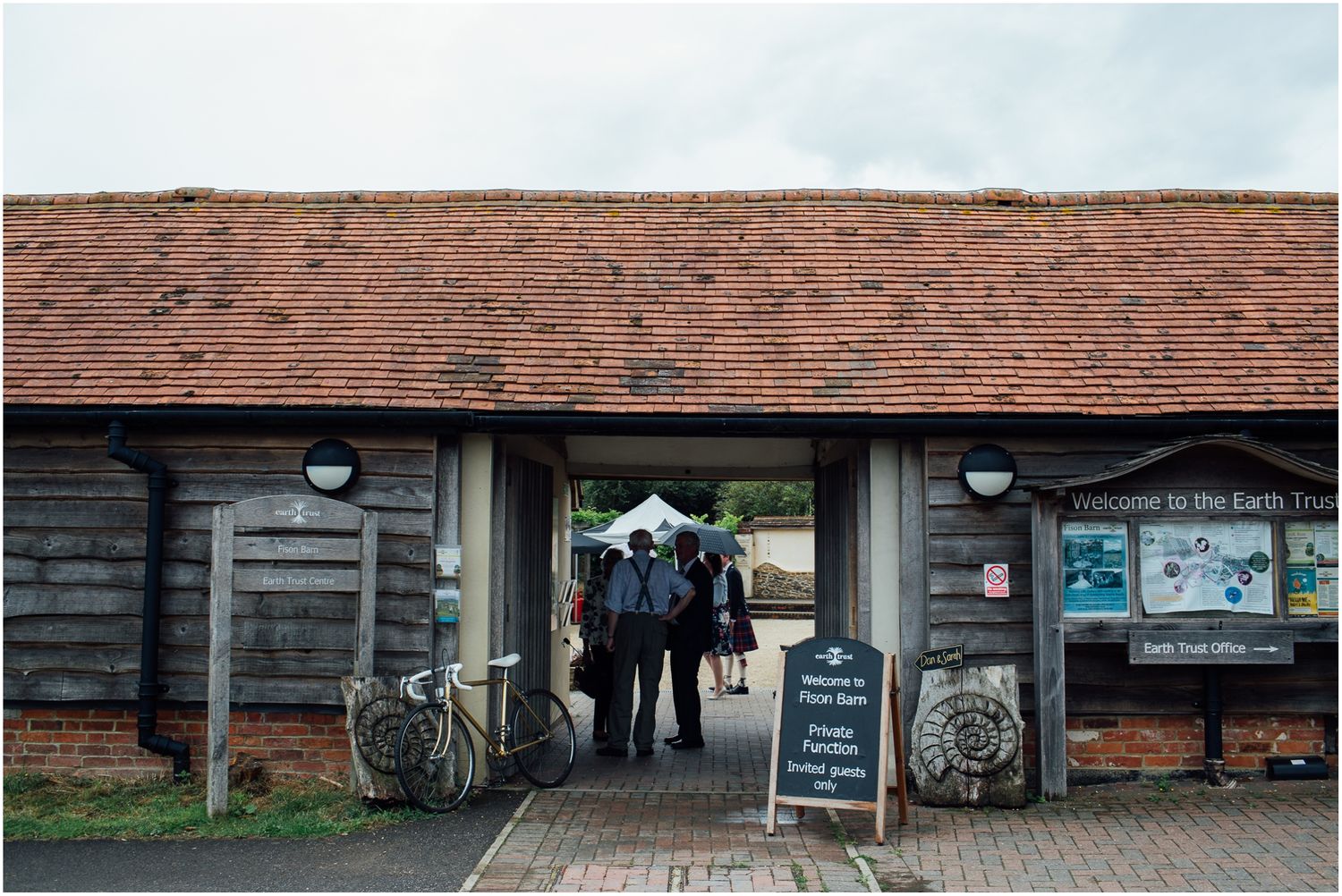 Wedding venue entrance with rustic barn wood exterior and bicycles parked outside.