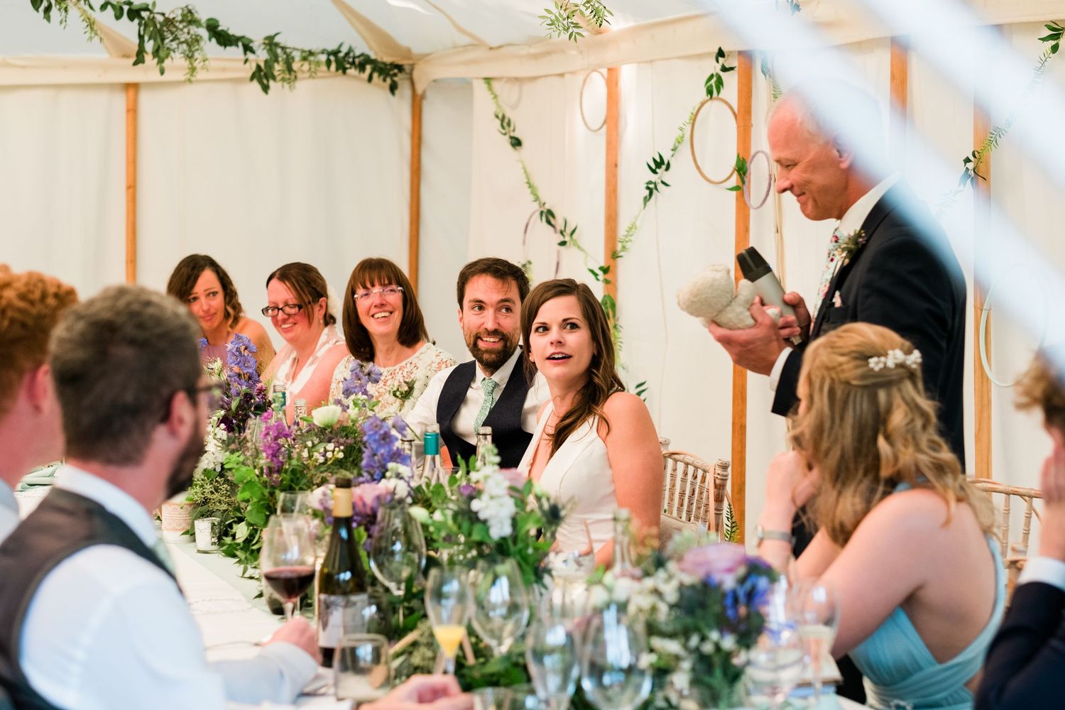 Candid moments of wedding guests enjoying dinner and conversation at a tented reception.