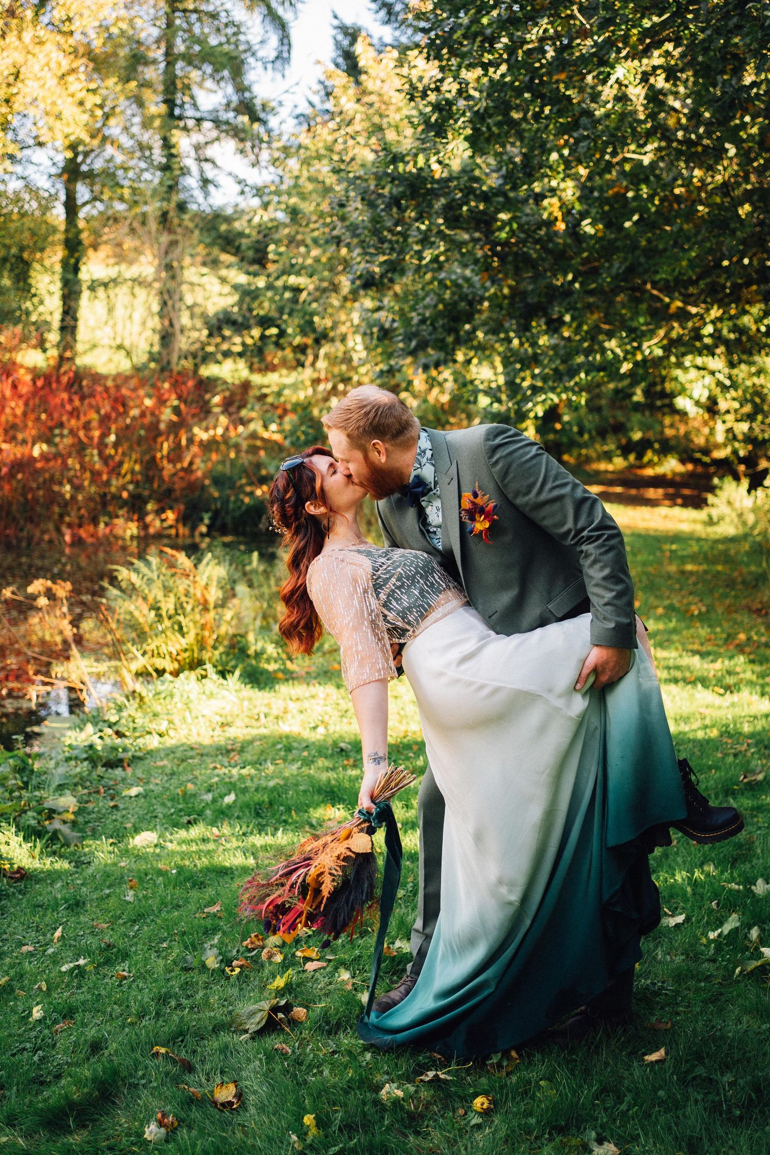 Romantic wedding portrait in an autumn garden with fallen leaves.