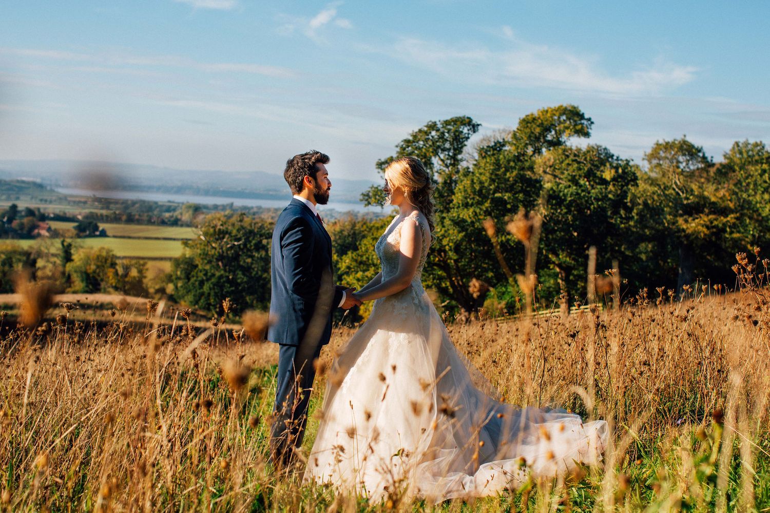 Wedding ceremony taking place in a scenic outdoor setting with mountains and blue sky.
