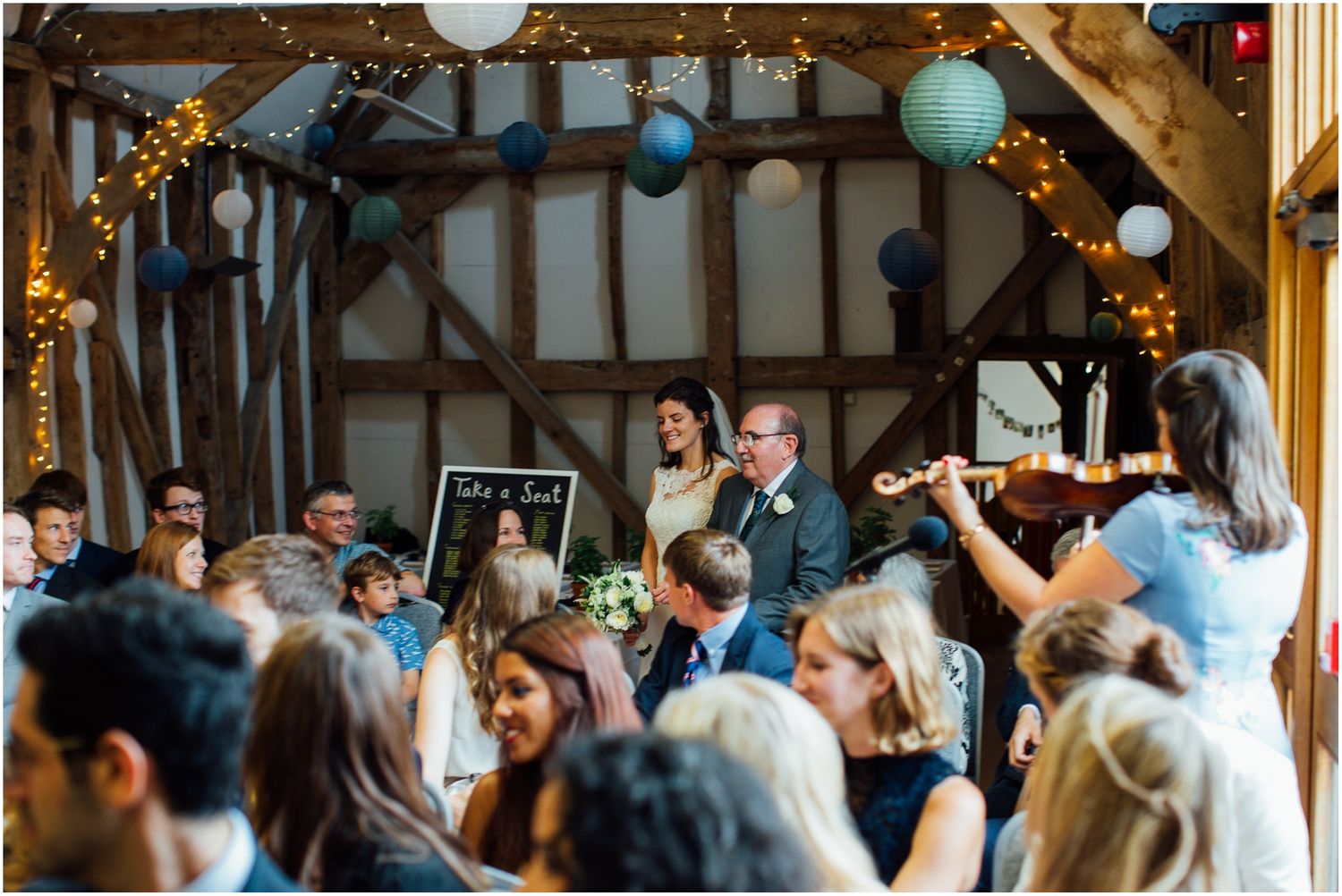 Wedding reception in a rustic barn venue decorated with string lights.