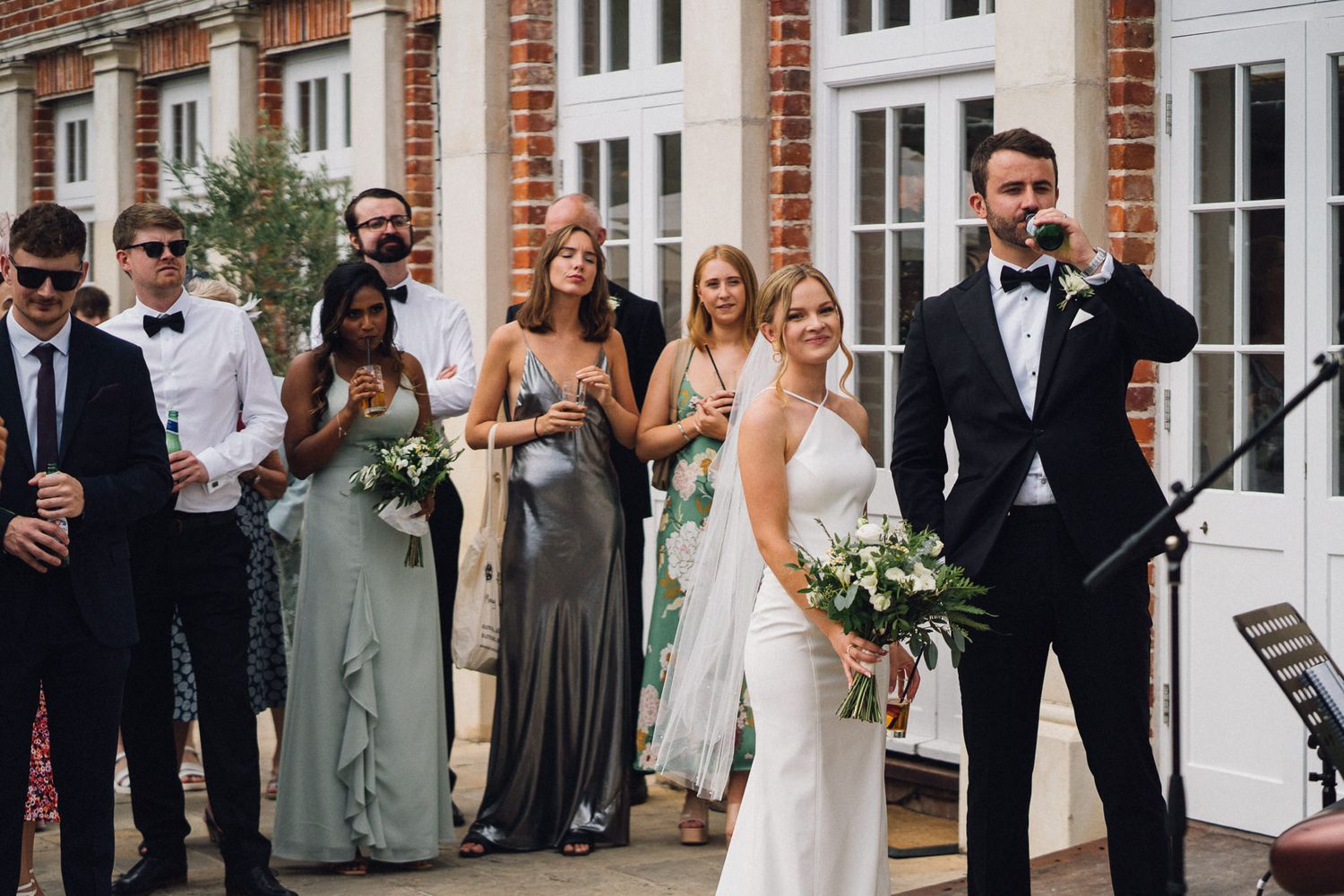 Wedding celebration at an elegant brick venue with guests mingling on the patio.