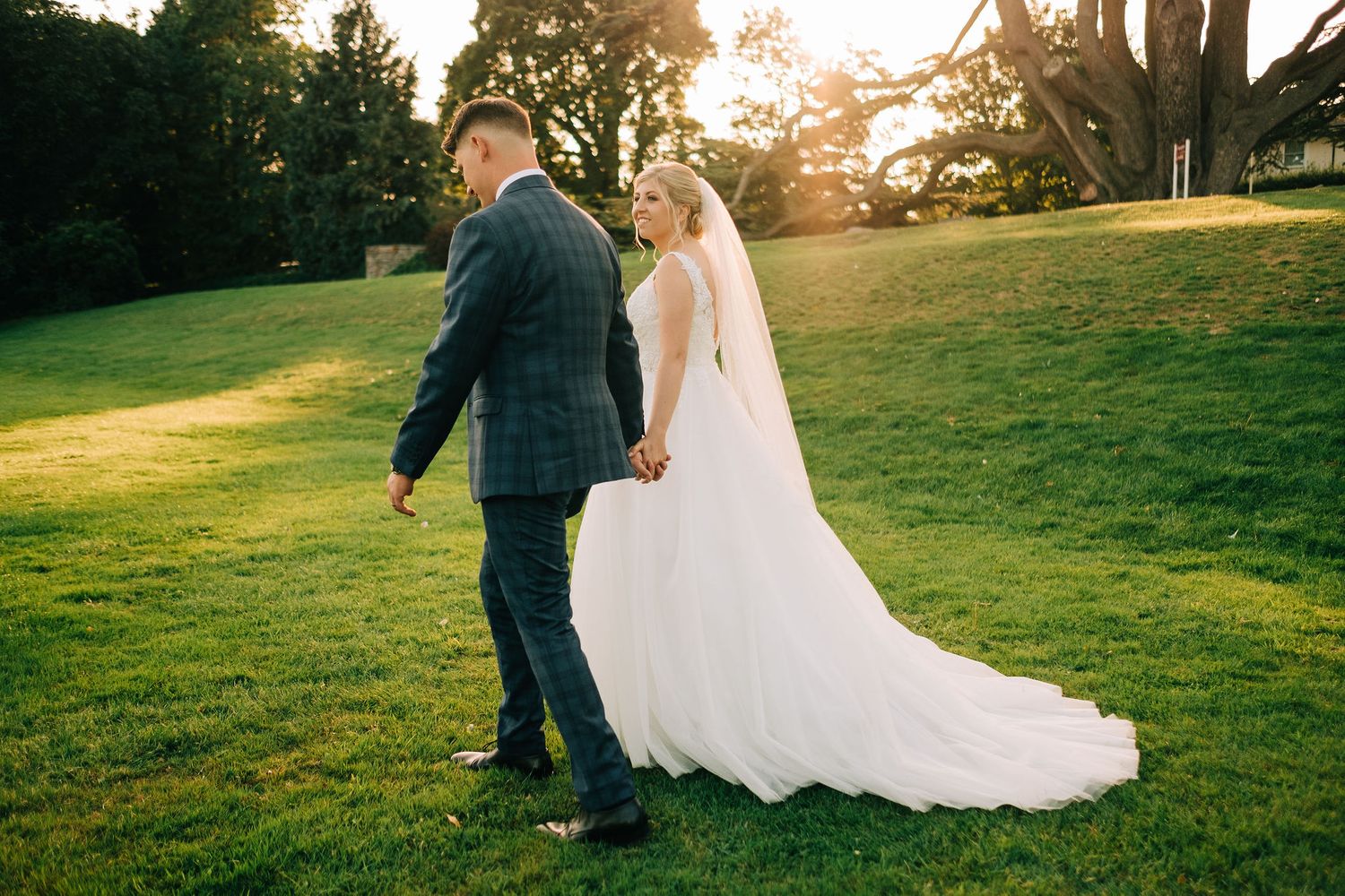 Sunset wedding photography session on expansive lawn.