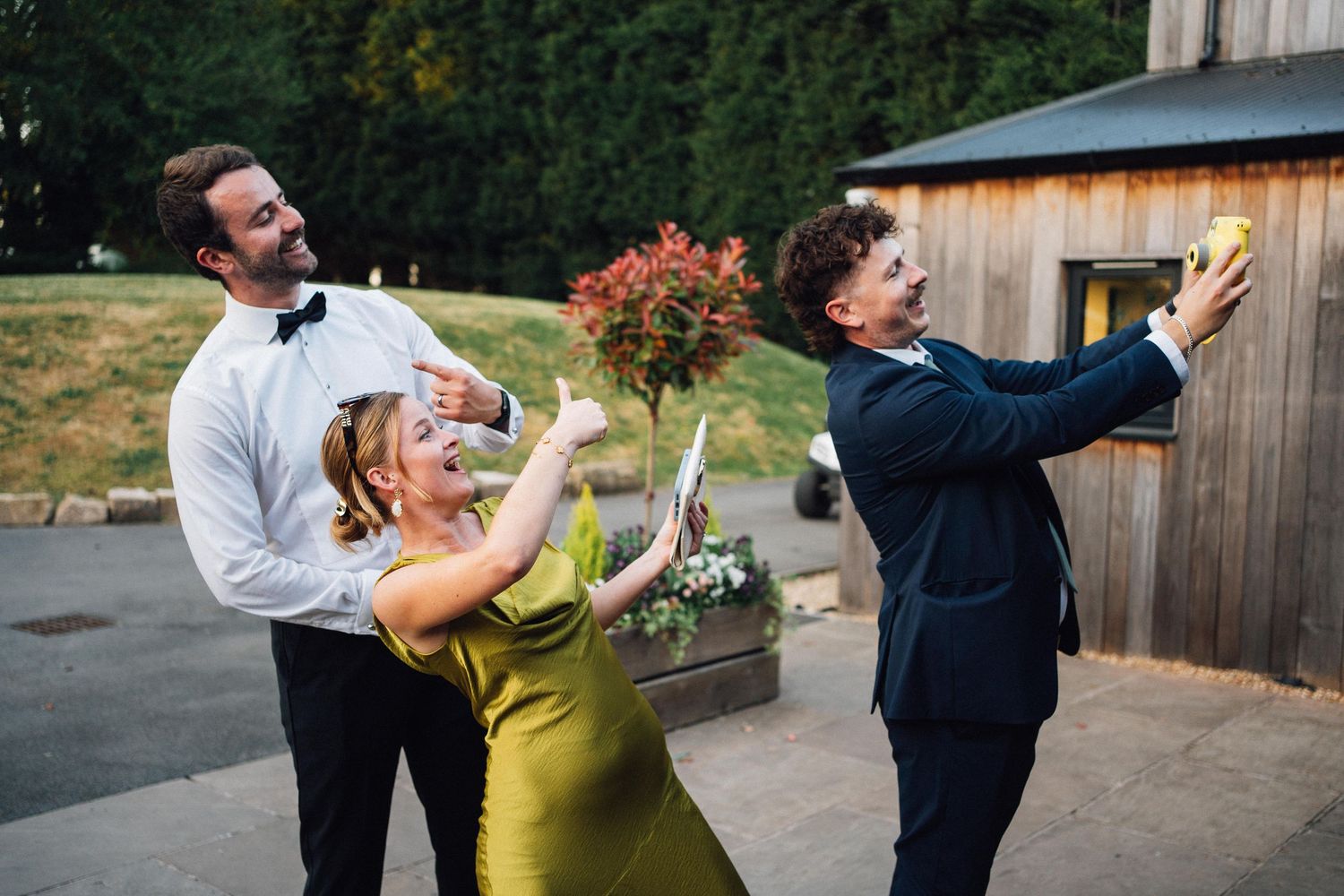 A series of joyful candid moments between a couple dancing and twirling together outside a rustic barn setting.
