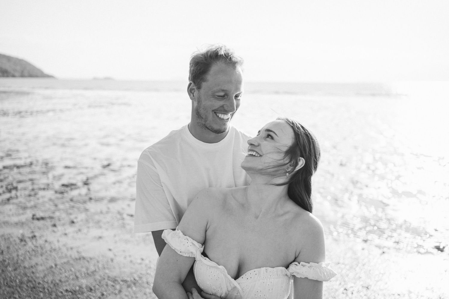 Candid moments captured between couple during sunset beach photoshoot.