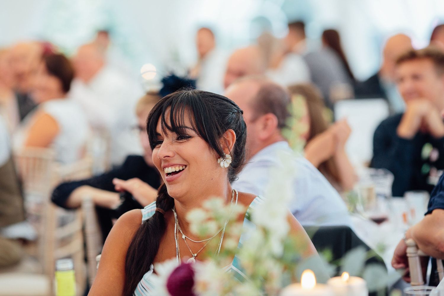 Wedding guests laughing and enjoying themselves during a reception celebration.