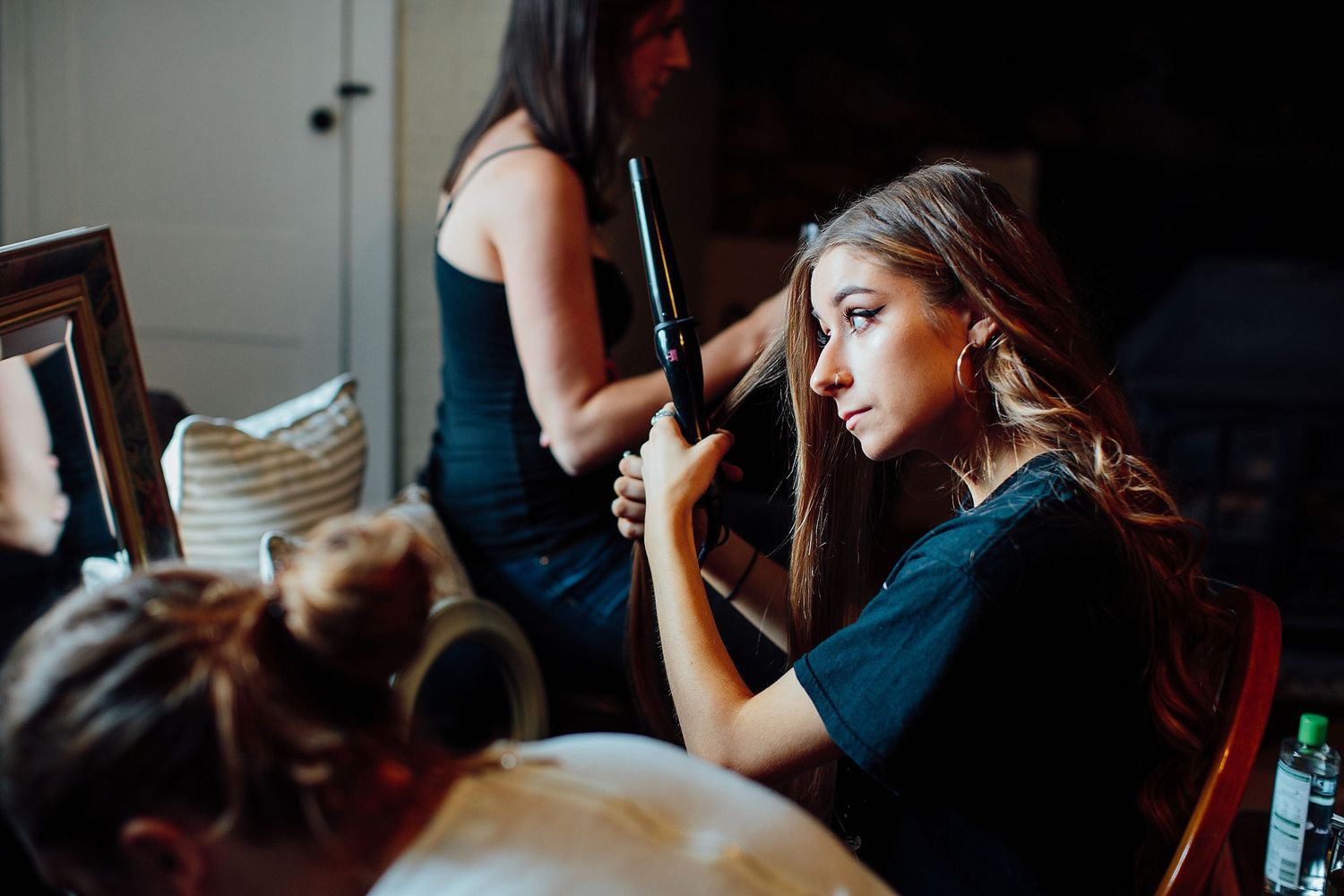 Someone having their hair styled and makeup done before a special event.