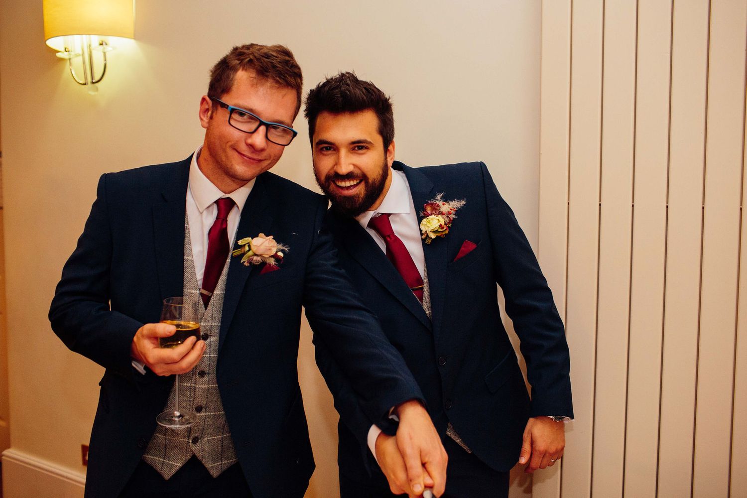 Groomsmen in navy suits sharing laughs during wedding reception festivities.