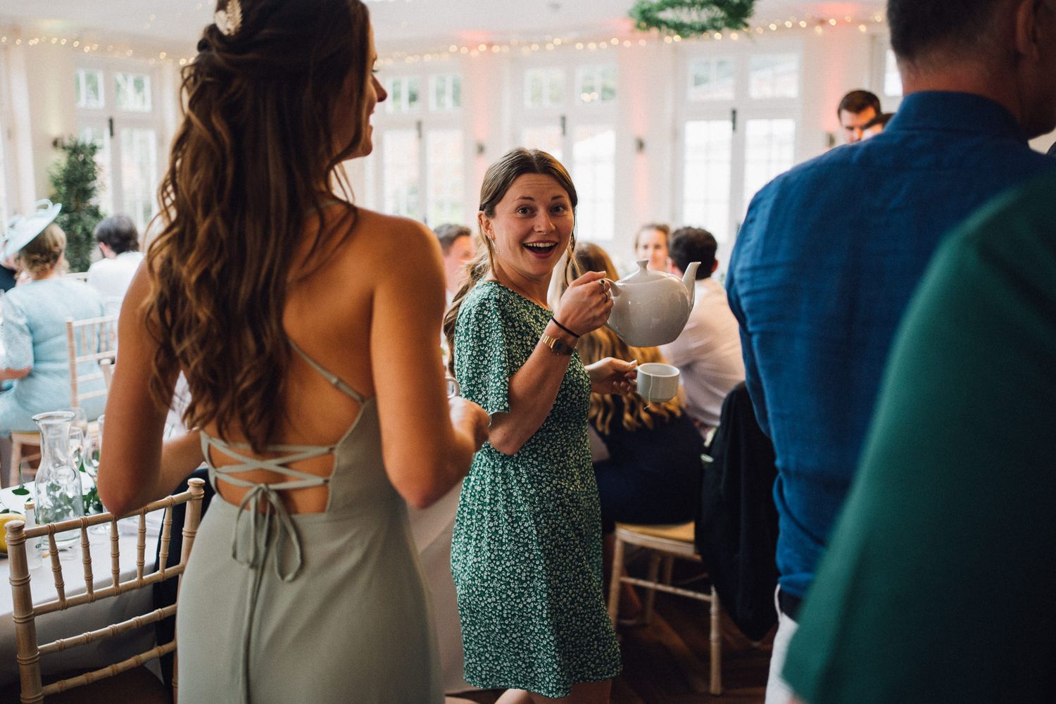 Wedding celebration candid moments captured during indoor reception with string lights.