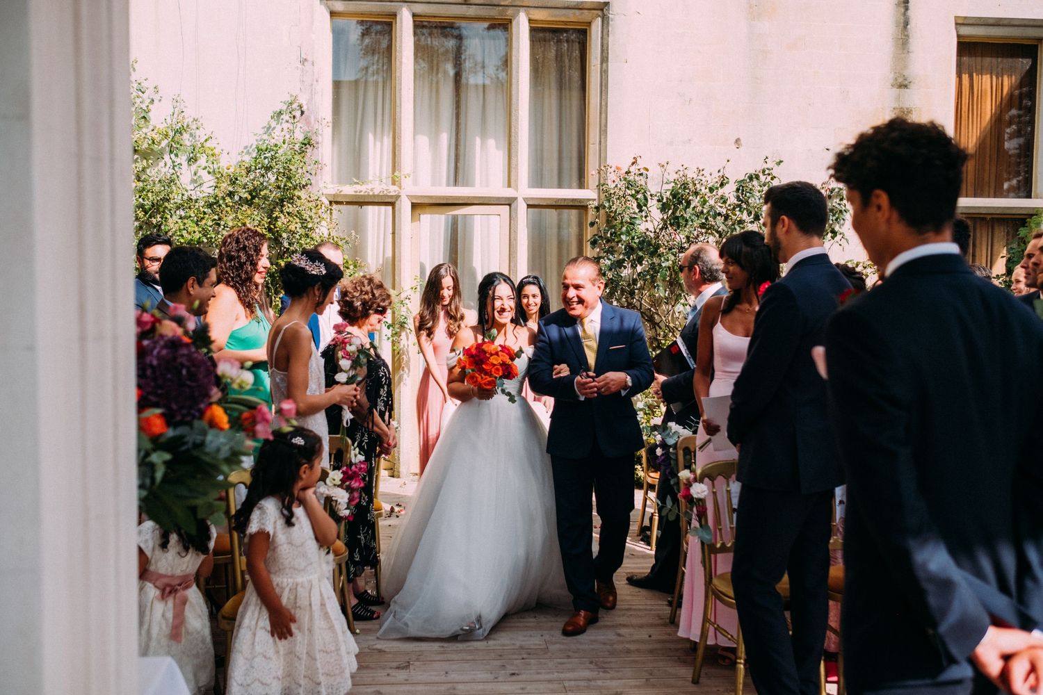 Wedding guests gathered in formal attire at an elegant indoor reception venue.