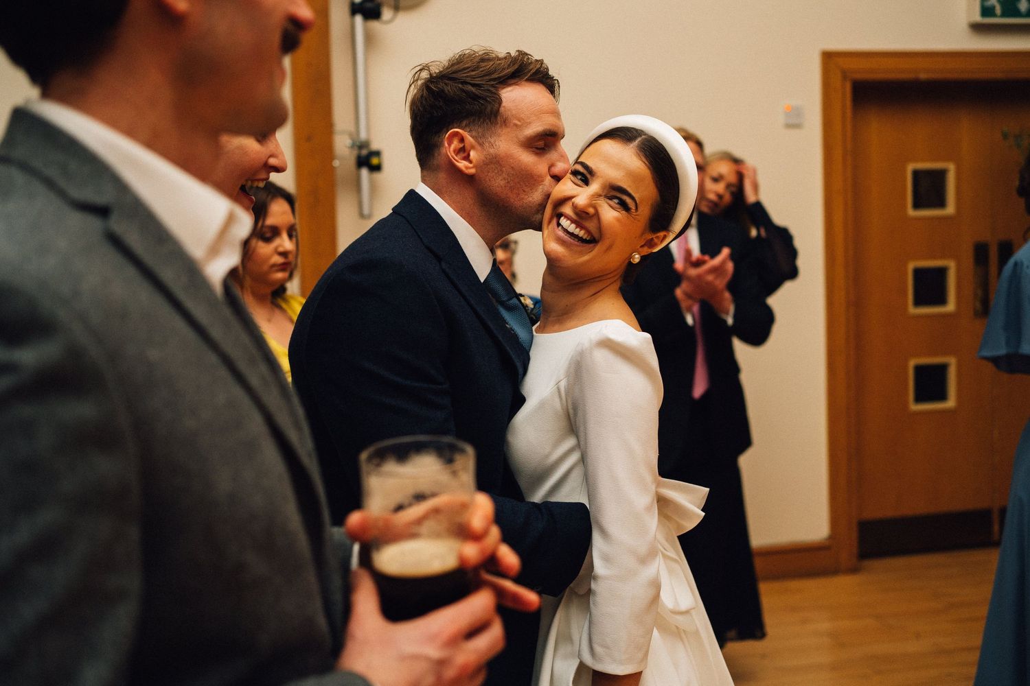 A joyful couple shares their first dance at a wedding reception in a warm-lit venue.
