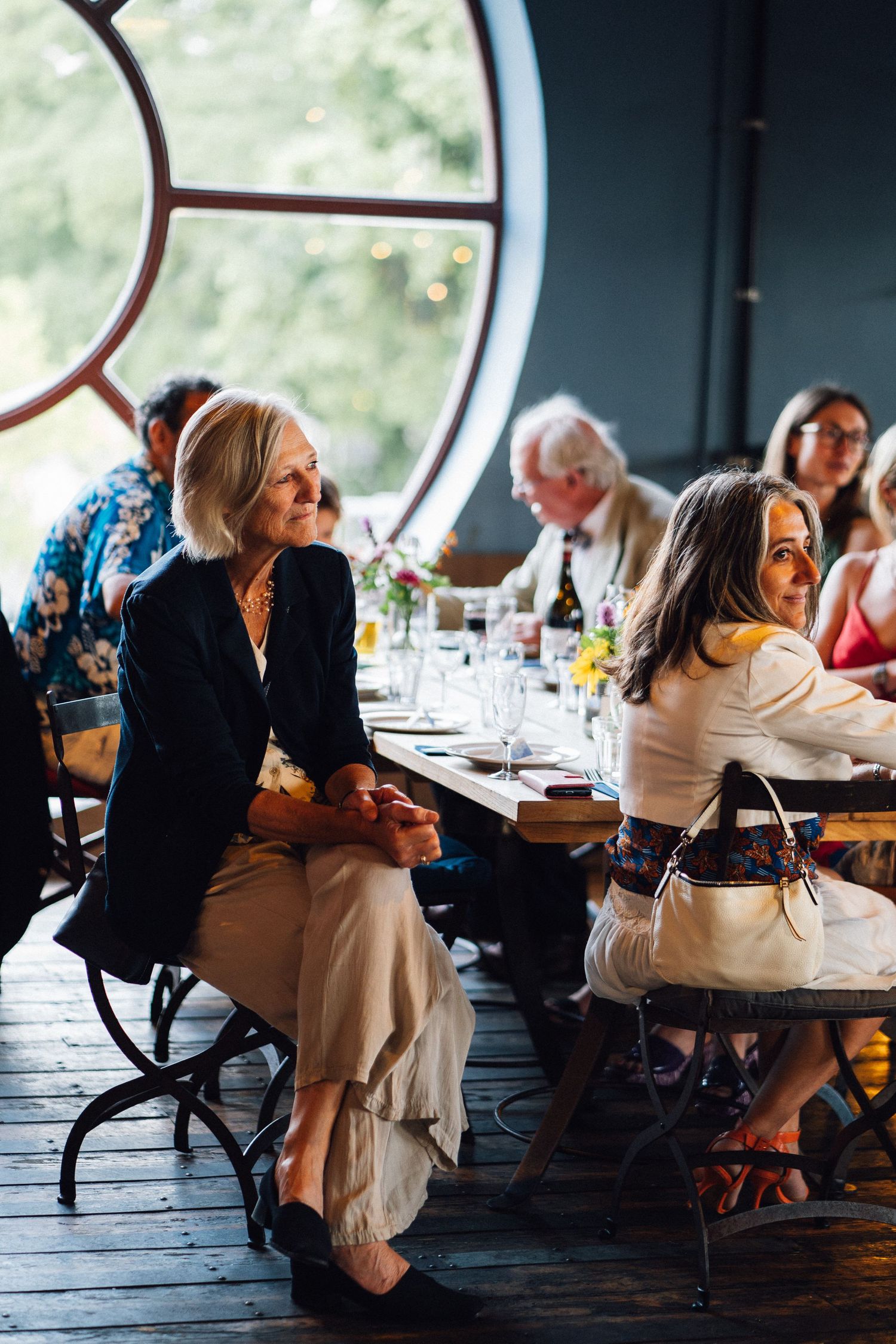 Wedding reception guests seated at tables in an elegant restaurant setting.