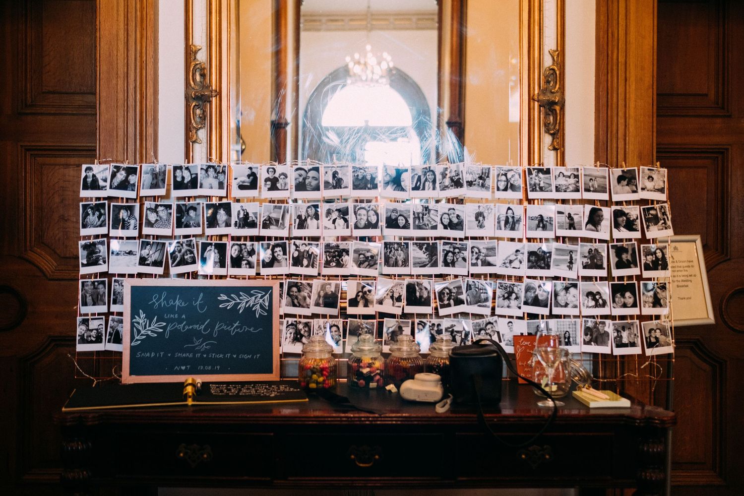 A vintage-style photo display wall with multiple black and white photographs arranged in rows.
