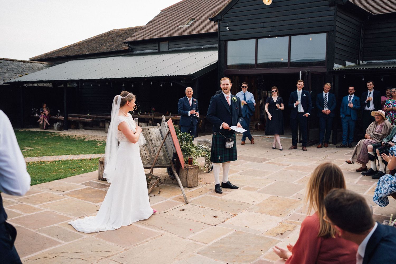 Wedding ceremony outdoors at a rustic venue with Scottish traditional elements.