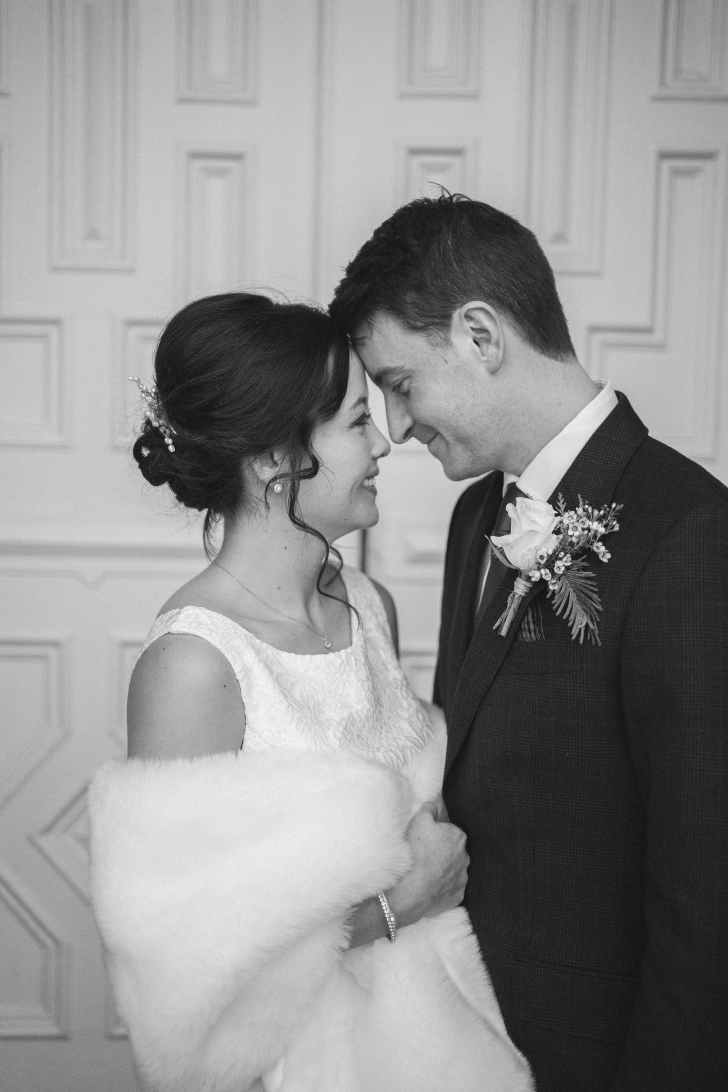 Black and white wedding portraits showing tender moments between newlyweds.