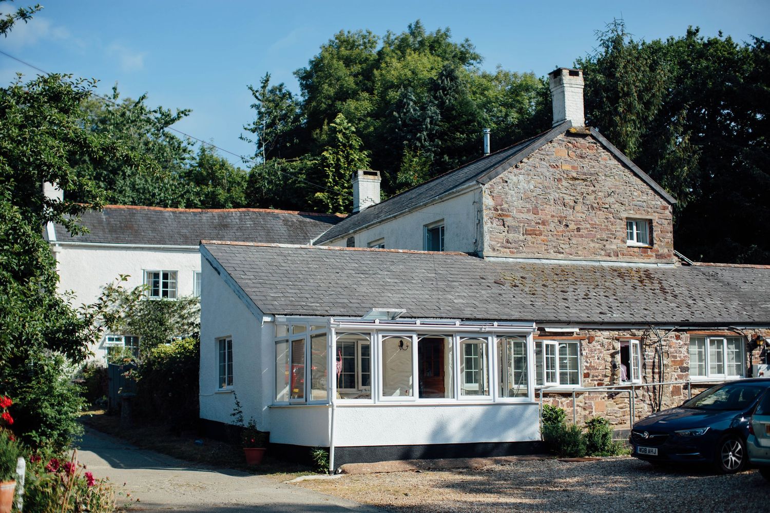 Exterior view of a long single-story stone and white building with multiple windows.