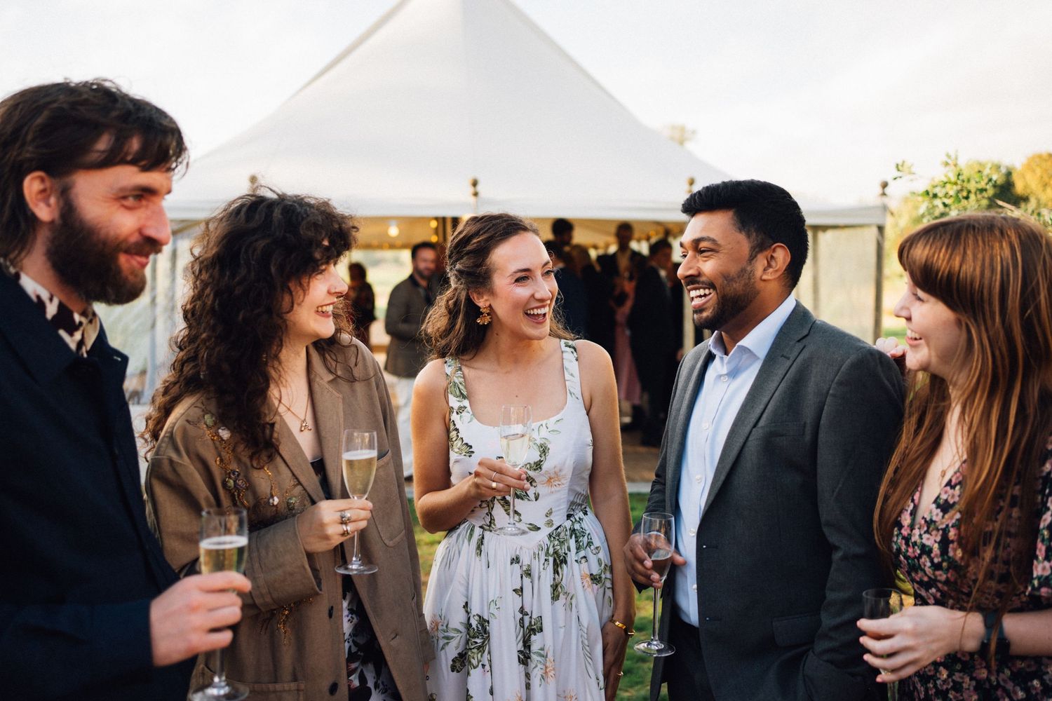 A group of people chatting and laughing together at a social gathering or party.