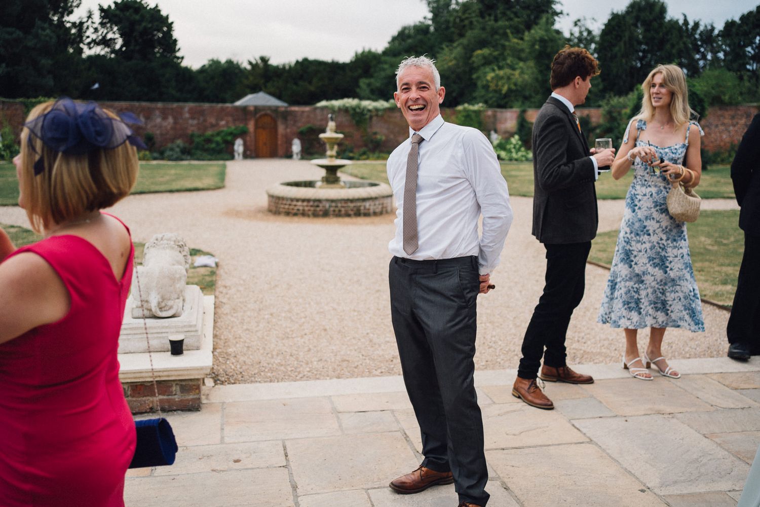 Wedding guests mingle and socialize at an outdoor reception venue.