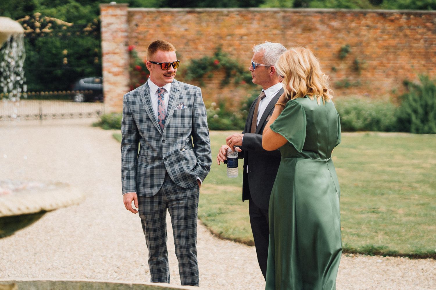 Wedding guests enjoy conversation during an outdoor summer celebration.