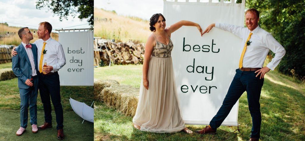 Wedding party holding signs spelling out a message in an outdoor garden setting.