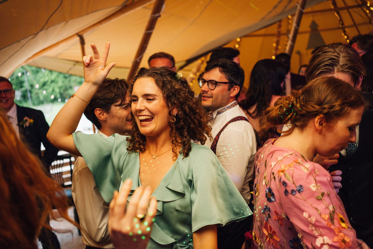 Energetic crowd dancing and celebrating at indoor party venue.