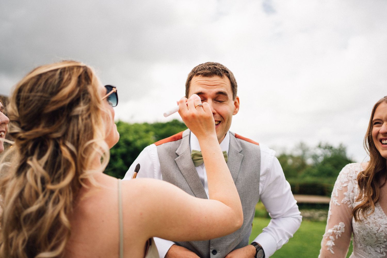 Candid moment of laughter and joy during outdoor wedding celebration.