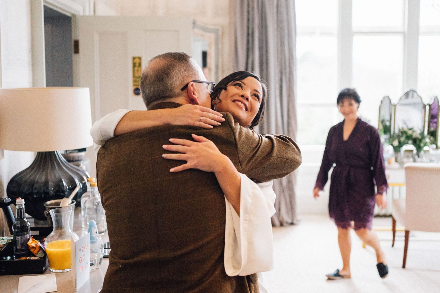 Candid moments shared during wedding morning preparations in a bright, sunlit room.
