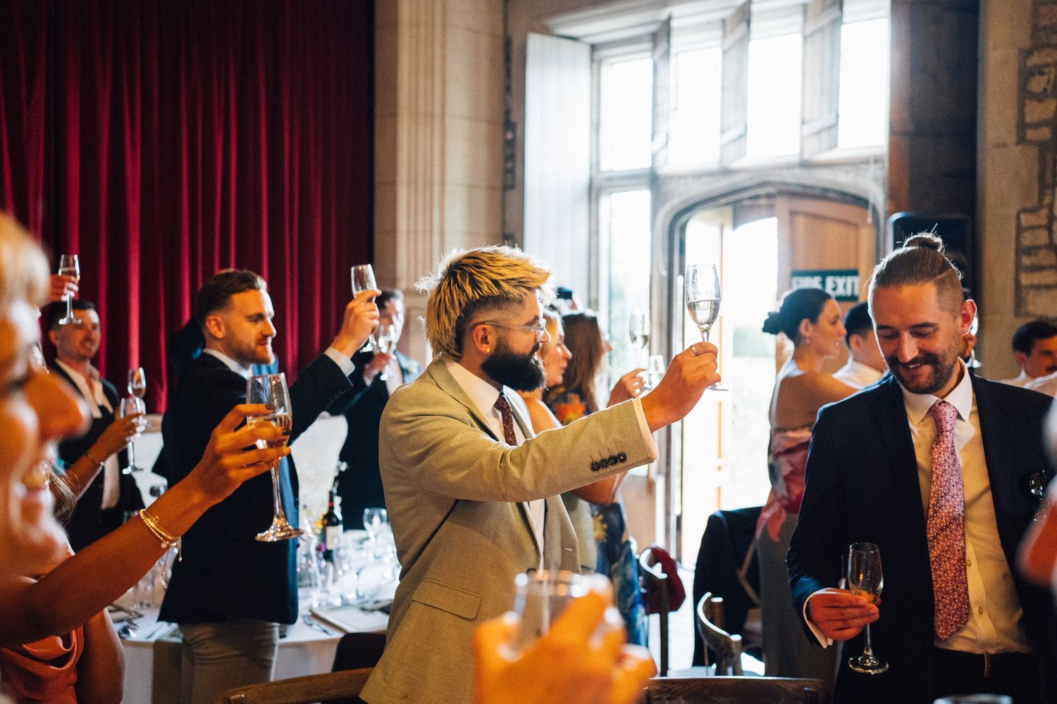 Wedding guests enjoying drinks and conversation at an elegant indoor reception.