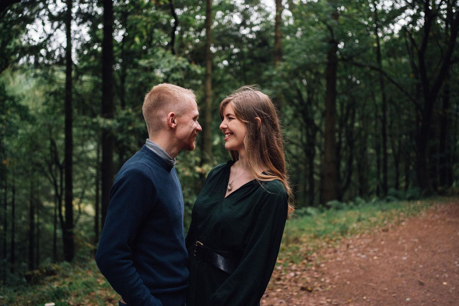 Romantic moment captured between two people on an autumn forest trail.