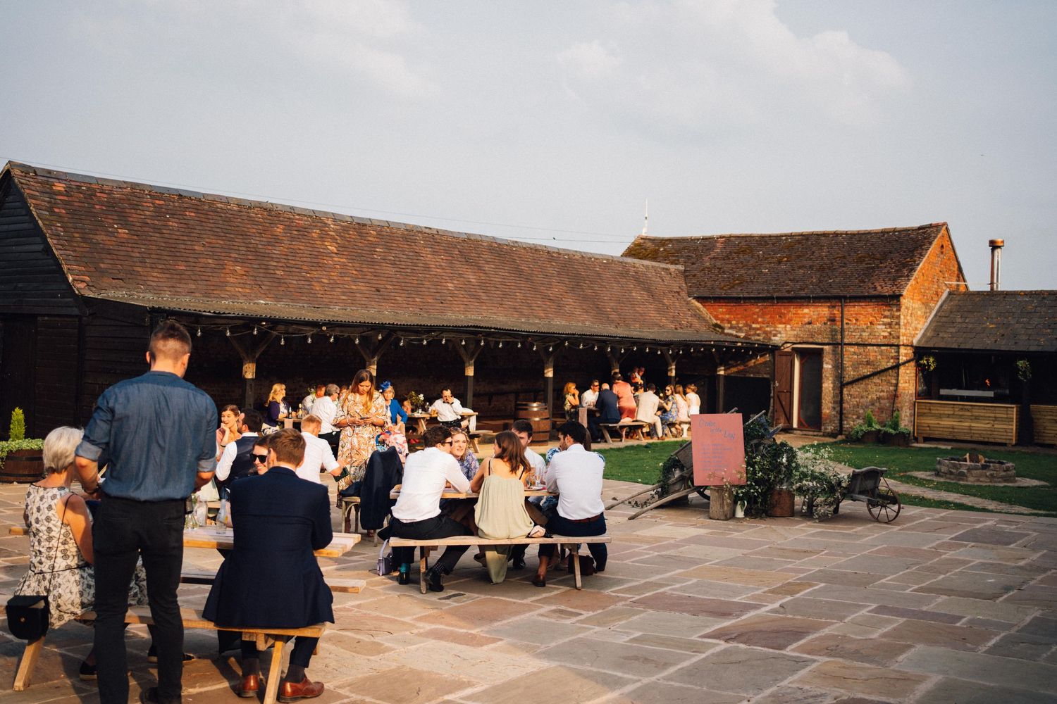 Panoramic view of rustic barn wedding venue with outdoor seating area.