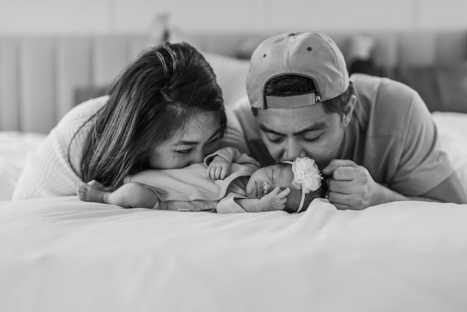 Happy family lying in bed together under white covers and spending relaxed time together.