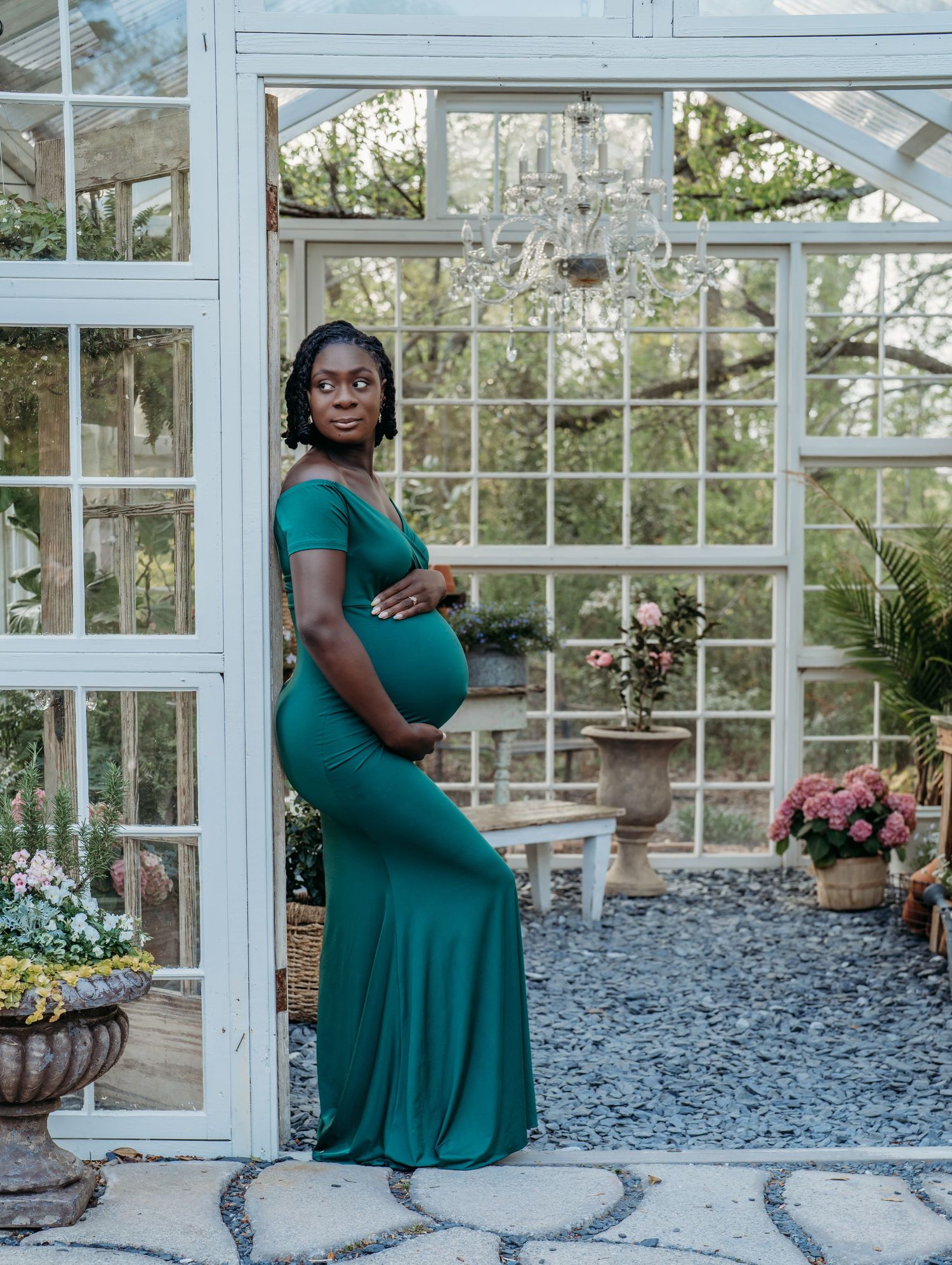 A series of four indoor greenhouse photos featuring someone in an elegant emerald green dress posing among potted plants.