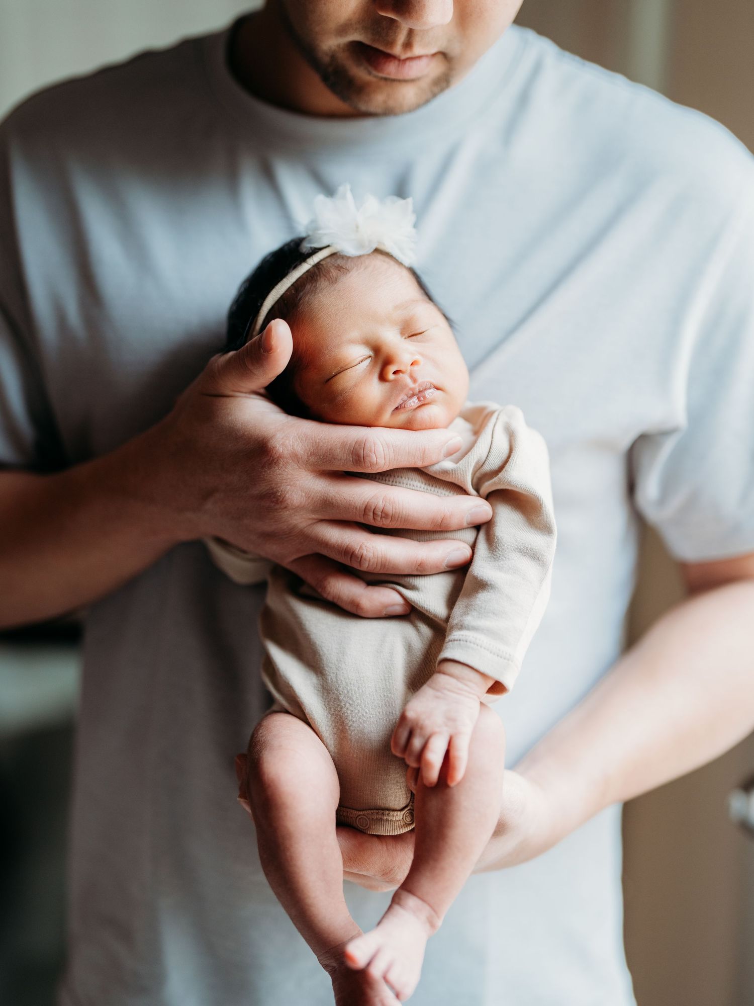 A collection of black and white photos showing gentle baby massage techniques performed by hands in a white shirt.