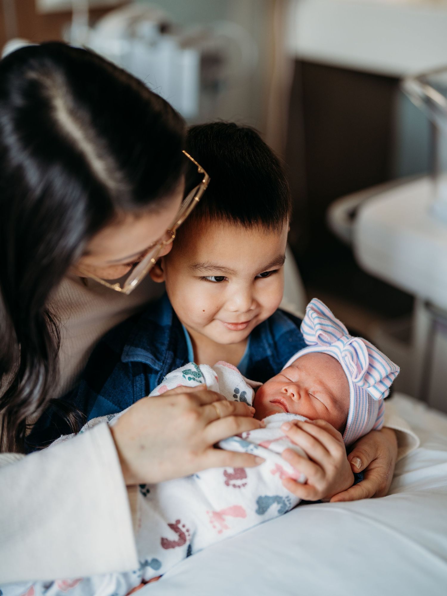 A tender moment captured in a series of intimate photos showing a baby being cradled by family members on white bedding.