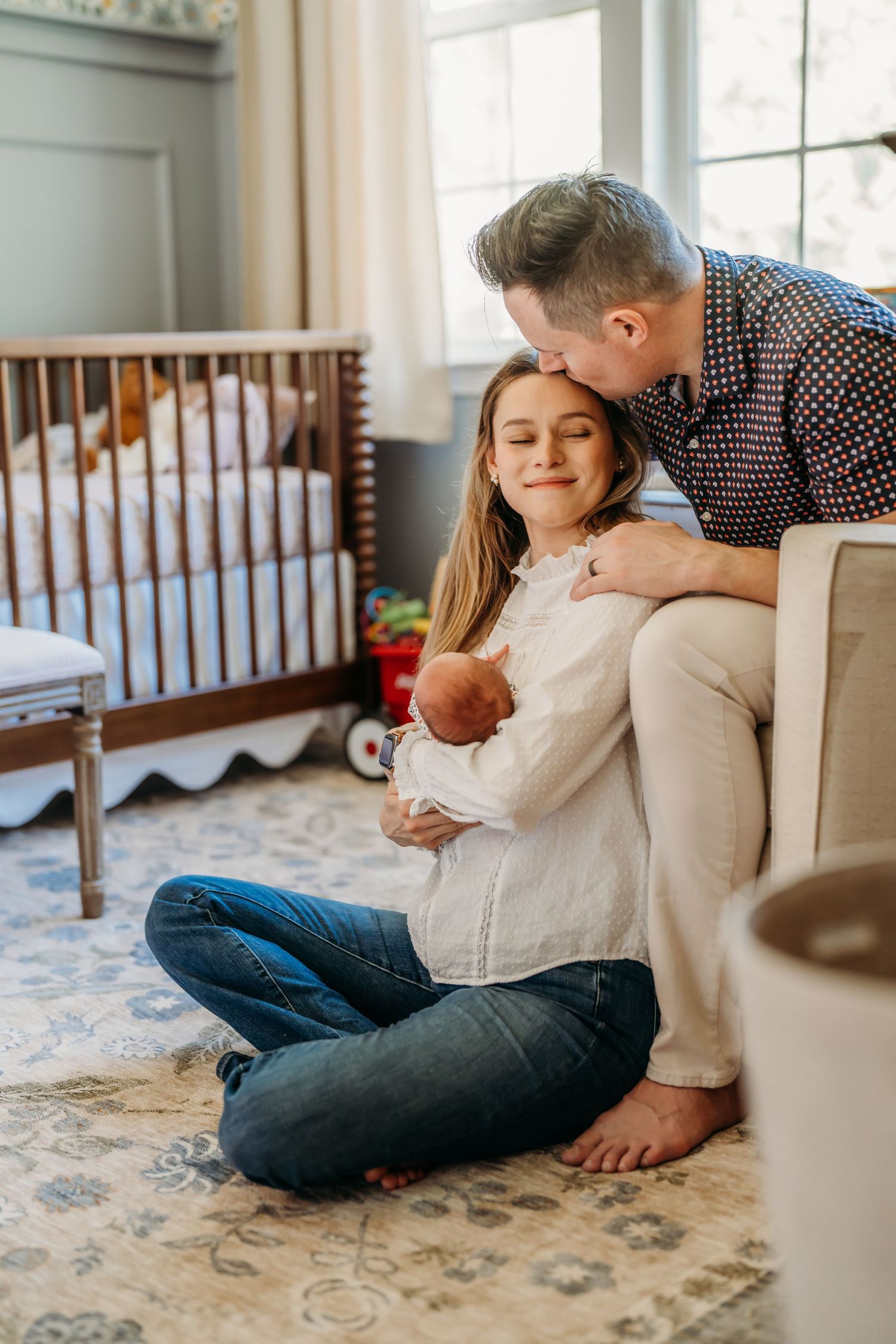 Tender family moments captured on a carpeted floor showing a parent and children cuddling together at home.