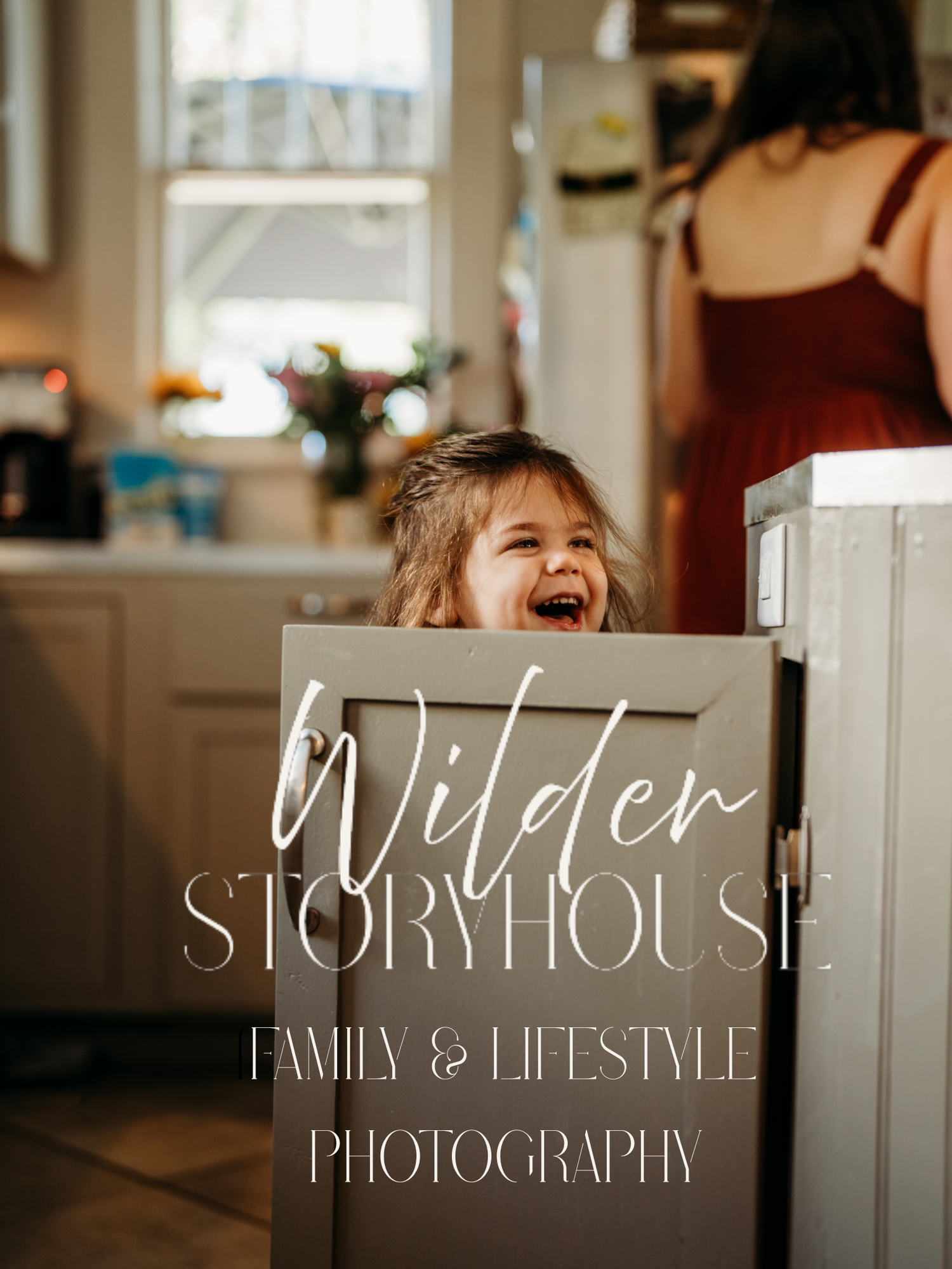Candid lifestyle photography branding showing joyful child laughing behind kitchen cabinet.