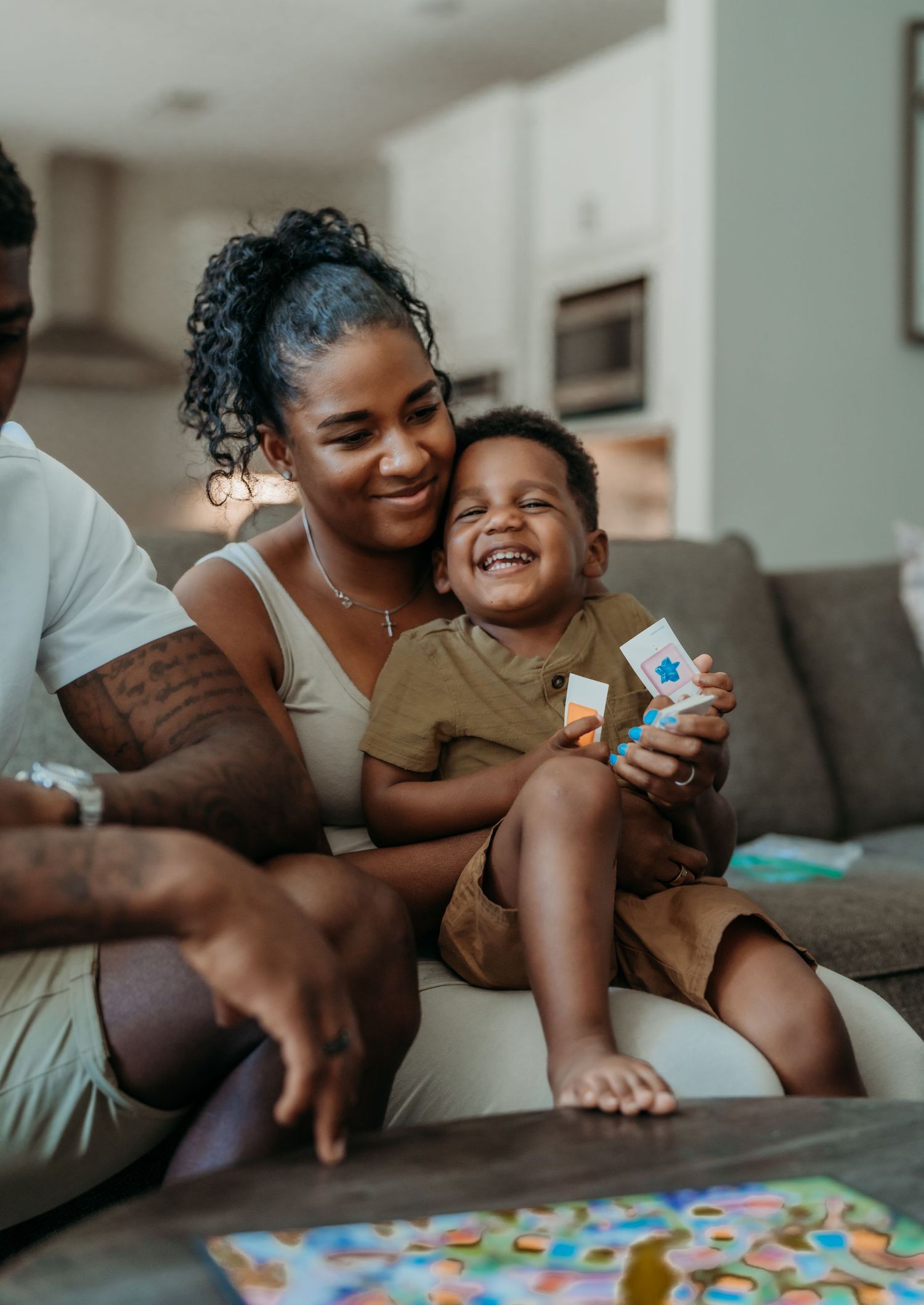 A joyful family moment spent playing with educational toys together on a couch in their living room.