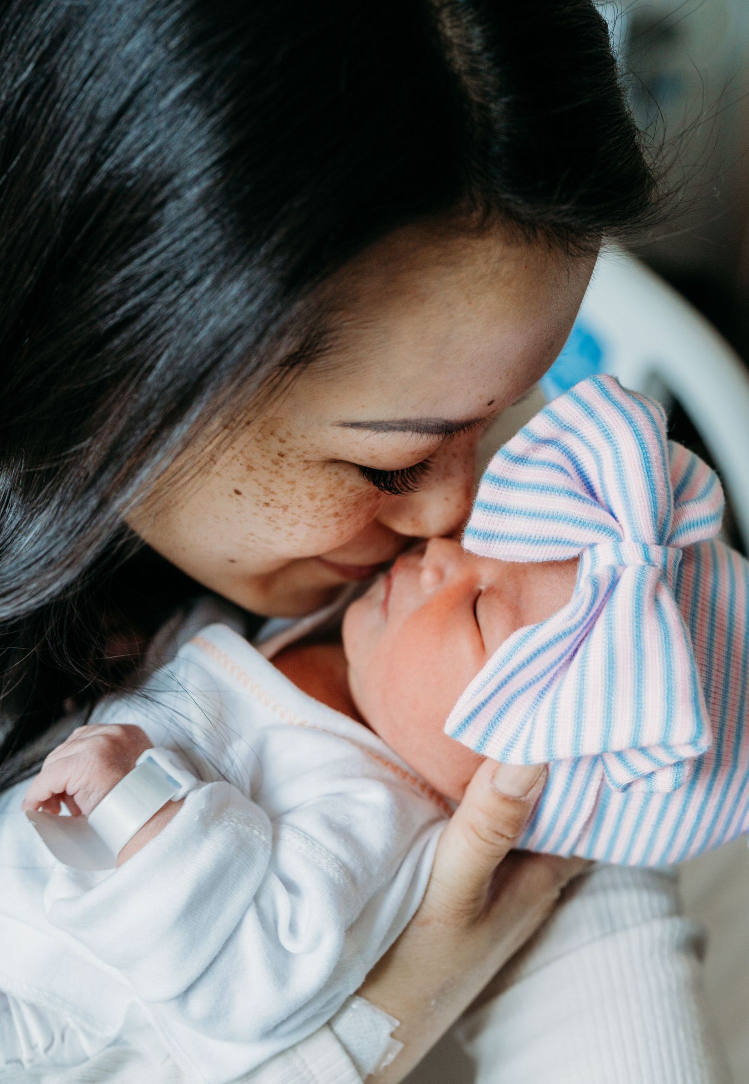 Nine candid photos show tender motherhood moments with a sleeping infant wrapped in blue and white striped blankets.