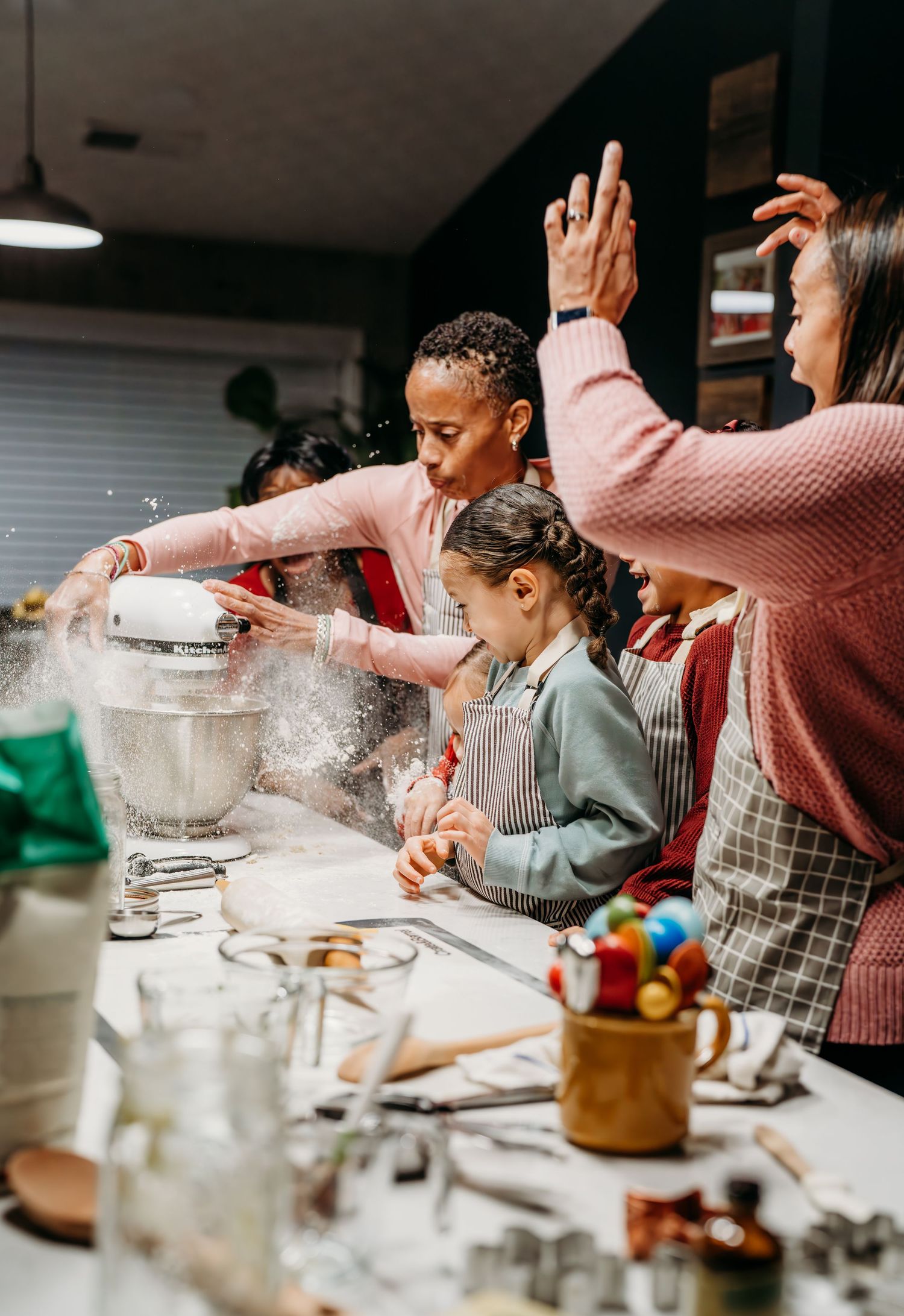A group of people in a kitchen sprinkle flour while baking together, creating a playful and messy atmosphere.