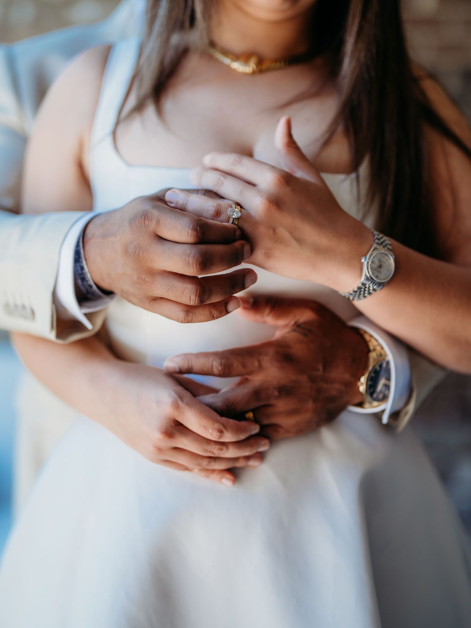 Close-up sequence of hands showing engagement rings and wedding bands on interracial couple.