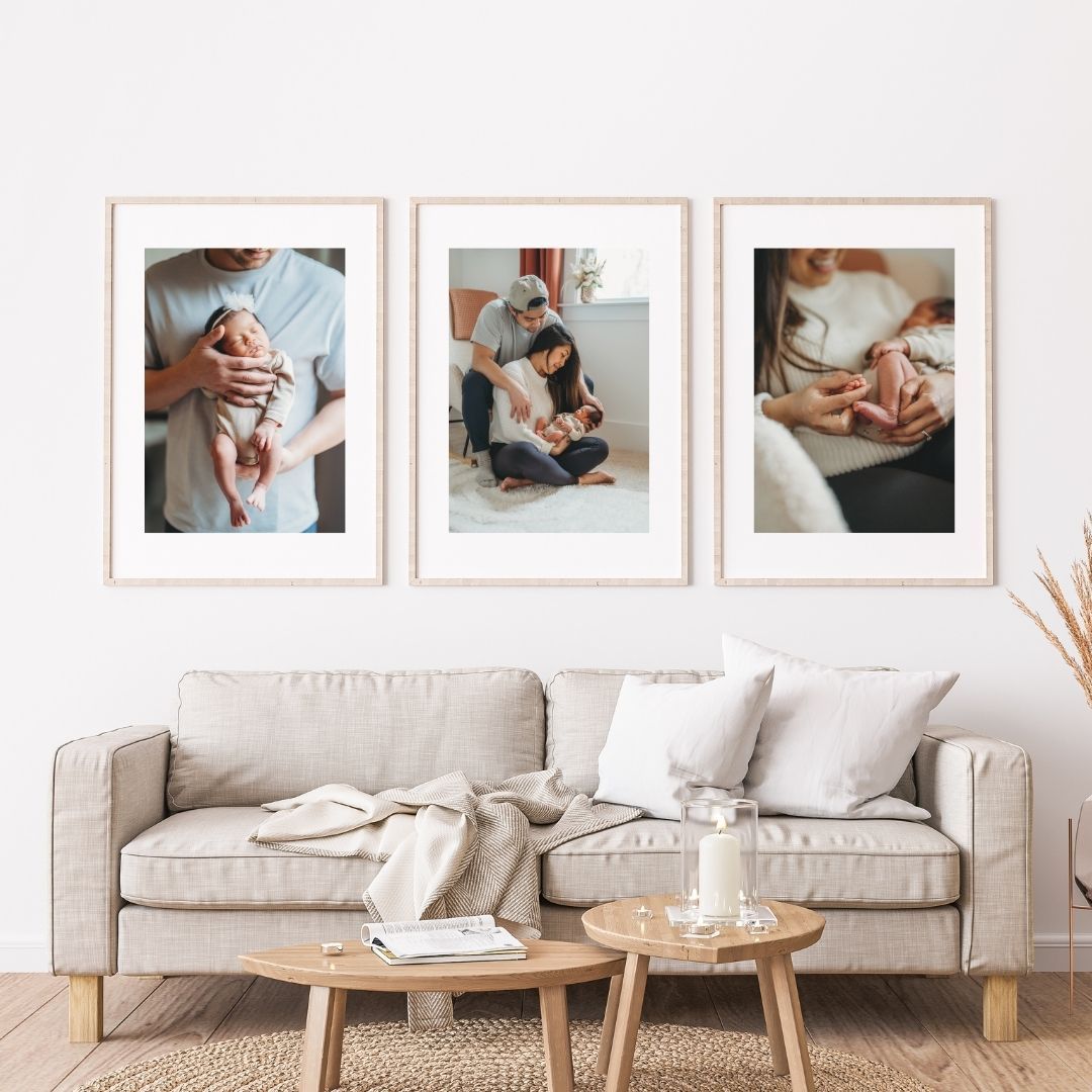 Minimalist living room interior with beige sofa, wooden coffee tables and framed wall art in natural tones.