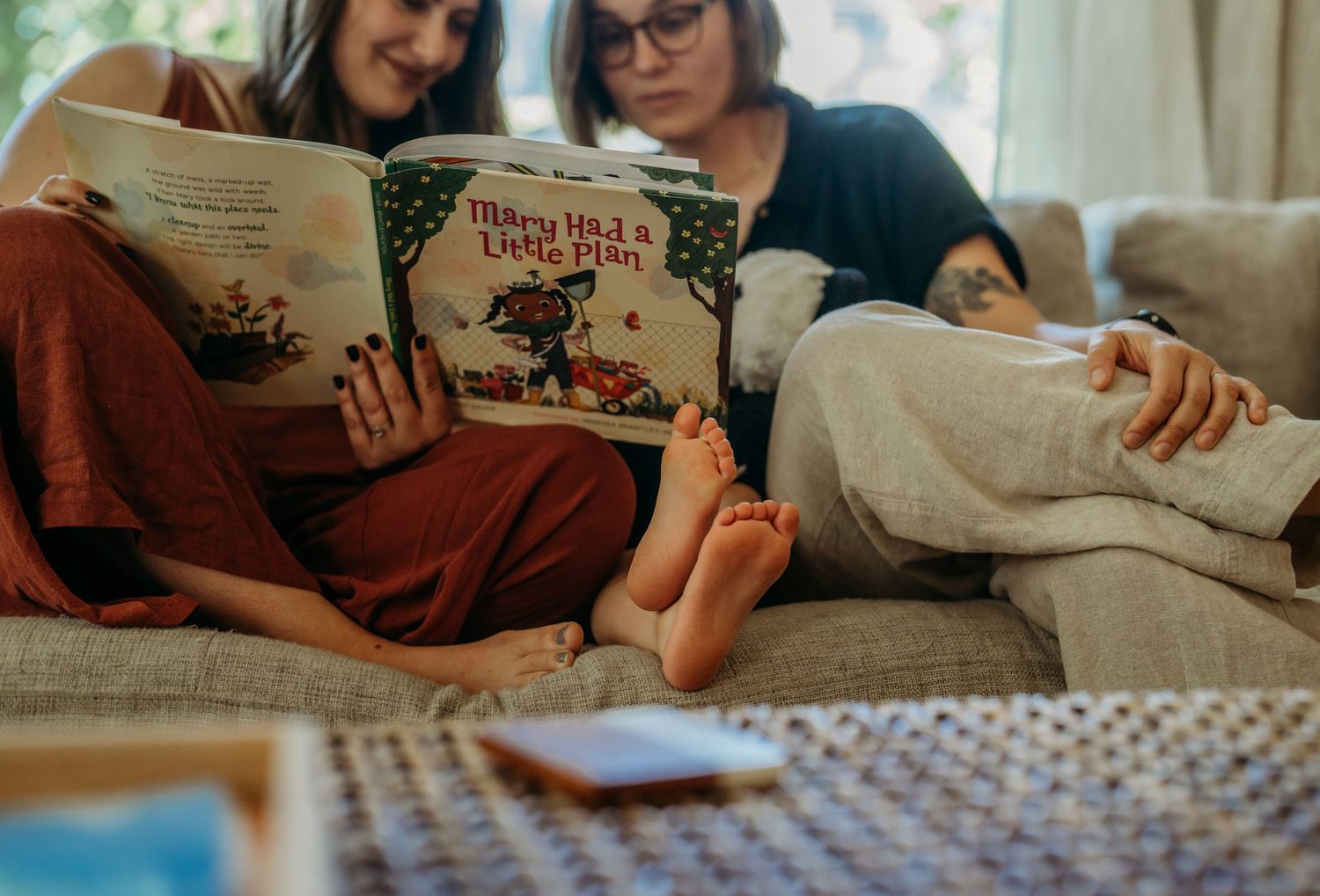 People relaxing at home while reading books and enjoying quality time together on a couch.