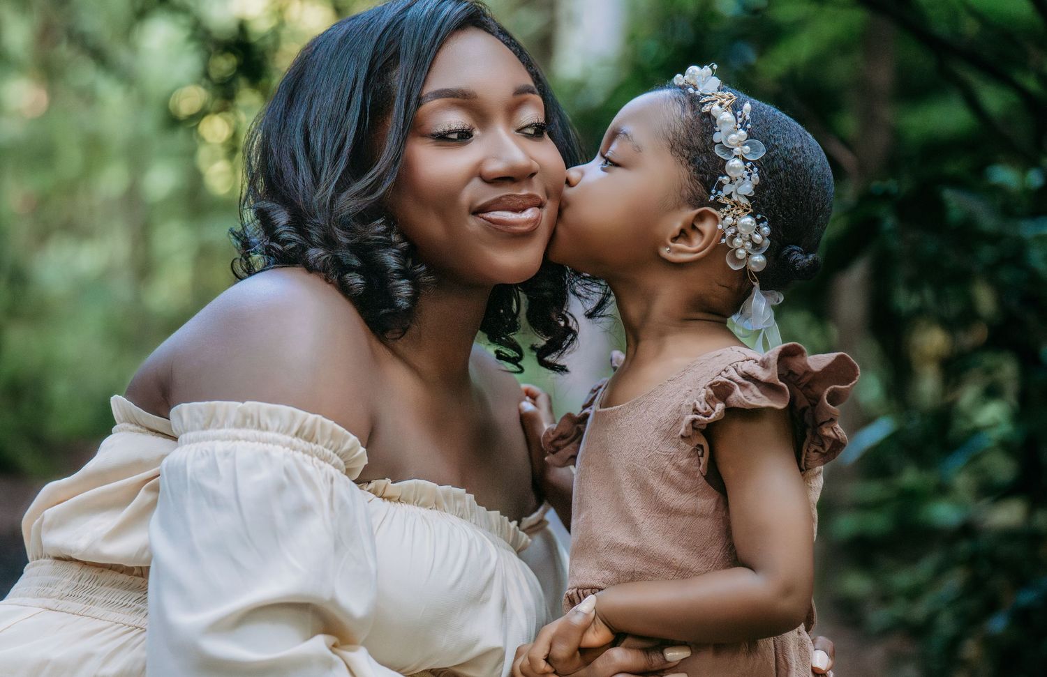 A couple shares joyful moments together during an outdoor photoshoot with lush greenery in the background.
