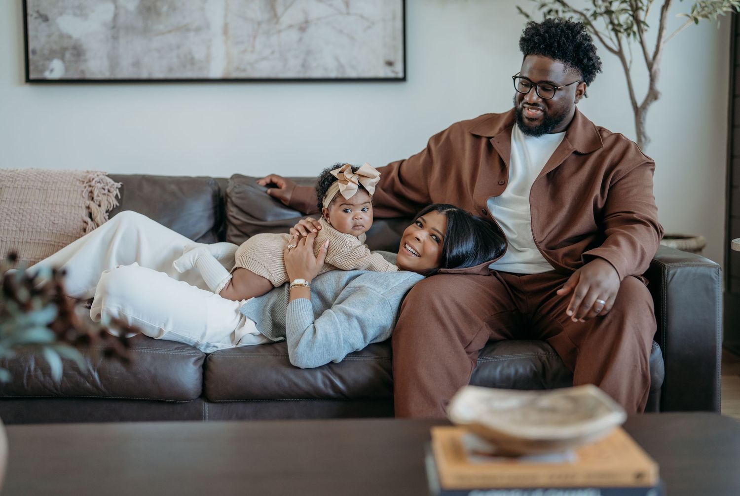 A family relaxes together on a gray couch in their cozy living room on a peaceful afternoon.