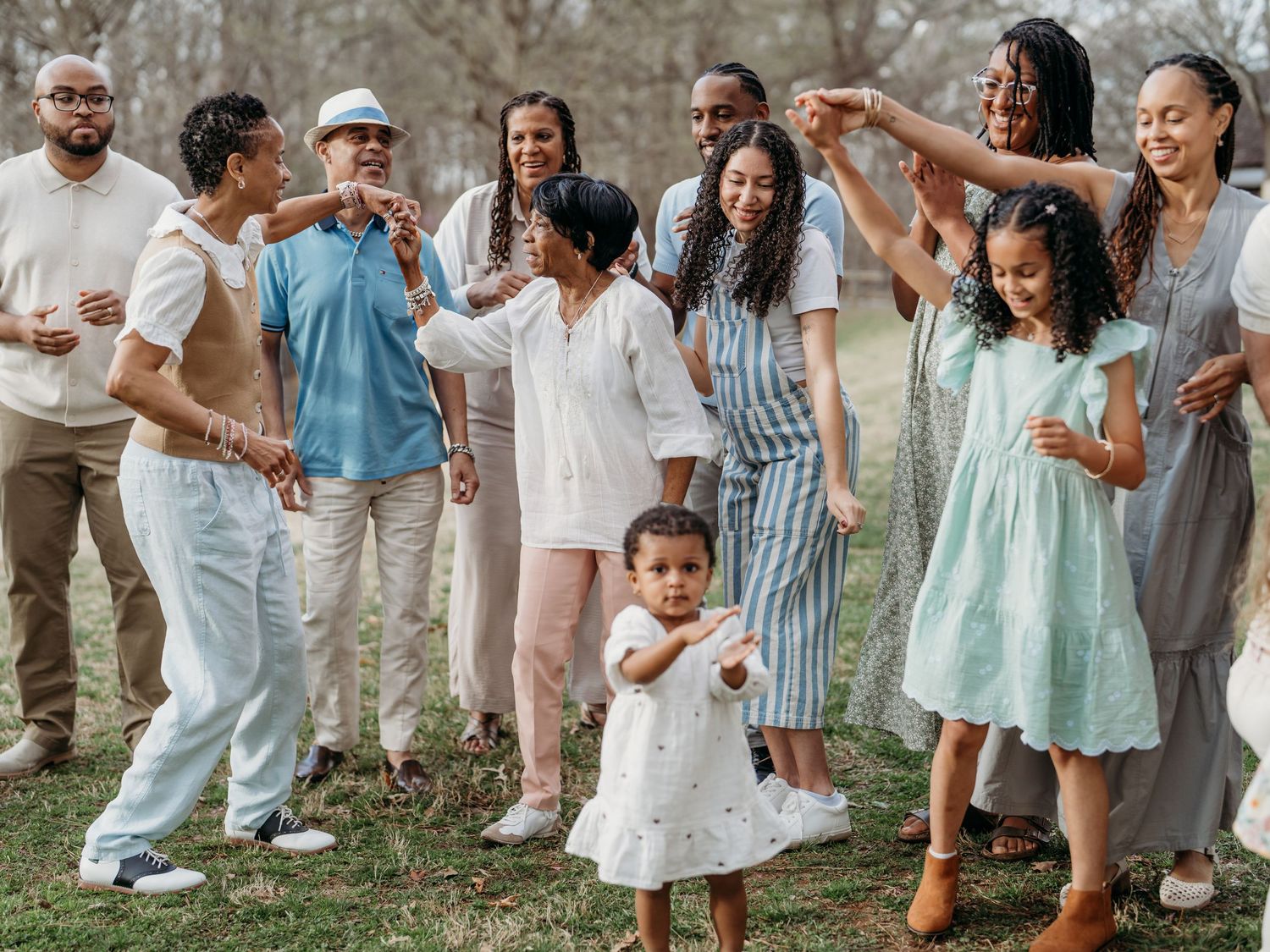 Multi-generational group enjoying a casual outdoor gathering while wearing light summer attire.